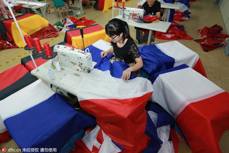 2016年6月12日,浙江绍兴一纺织品厂工人缝制国旗.